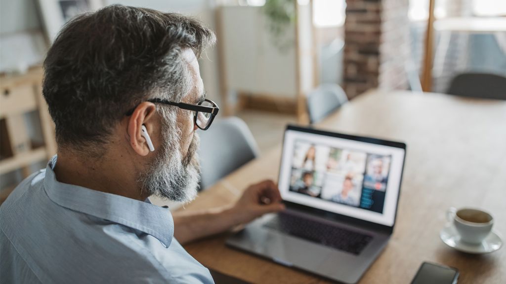 mand har et online møde og arbejder hjemmefra