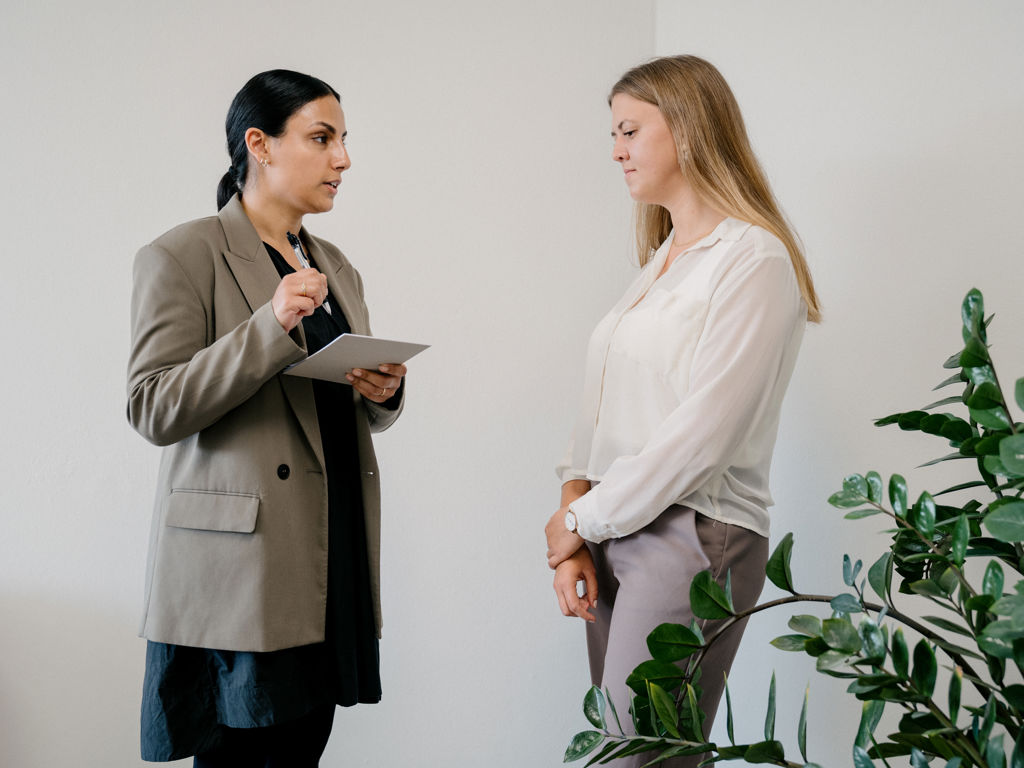 to kvinder står op og taler på et kontor