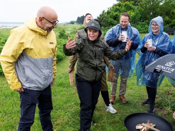 Flemming Møldrup og nogle tillidsvalgte taler sammen om bålet i regnvejr
