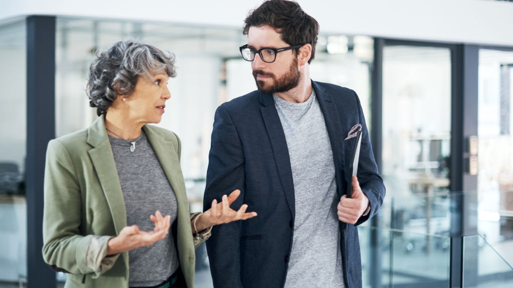 to mennesker taler sammen i mens de går