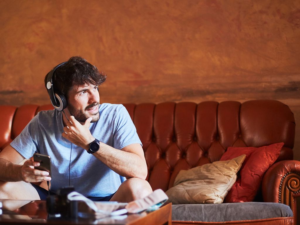 mand snakker i telefon i sofa