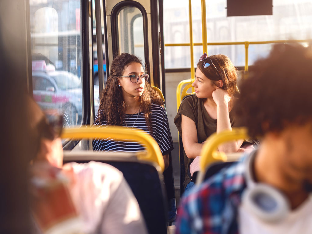 kvinder der sidder i en bus og taler sammen