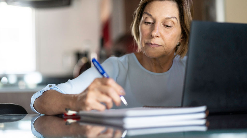 kvinde skriver ned i sin notesbog